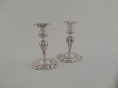 Appraisal: Two curious cast candlesticks on shaped bases with short columns