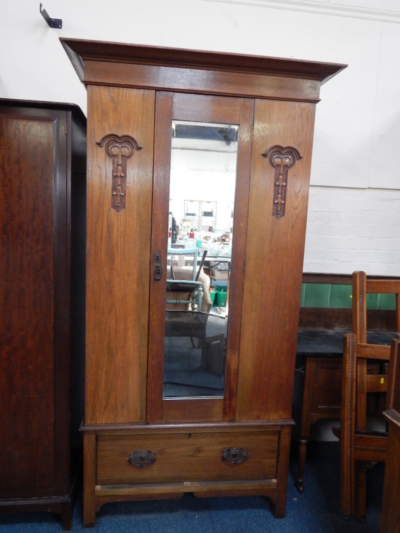 Appraisal: An Art Nouveau oak wardrobe the outswept pediment over a