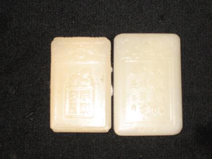 Appraisal: Two white jade pendantsTall rectangular form carved to show figural