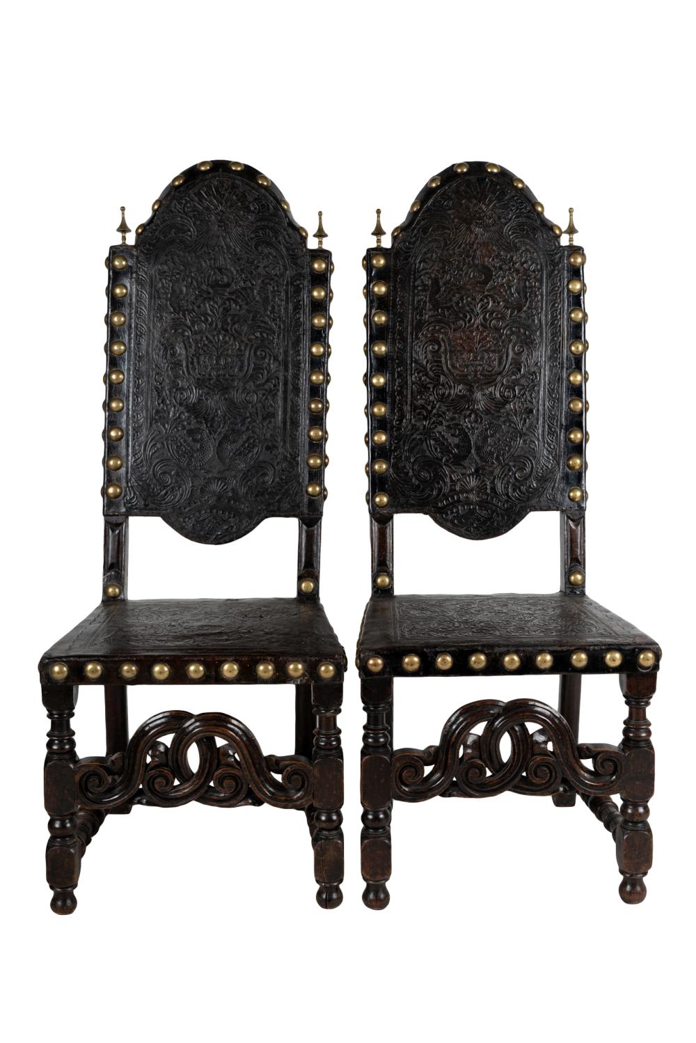 Appraisal: PAIR OF EMBOSSED LEATHER WOOD CHAIRSwith brass studs and finials