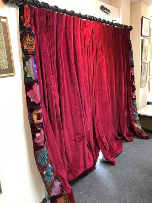 Appraisal: A pair of crimson velvet curtains with patchwork borders and