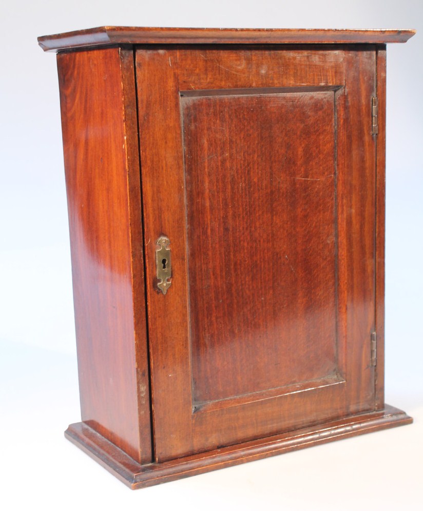 Appraisal: An Edwardian smoker's cabinet the panelled door hinging to reveal