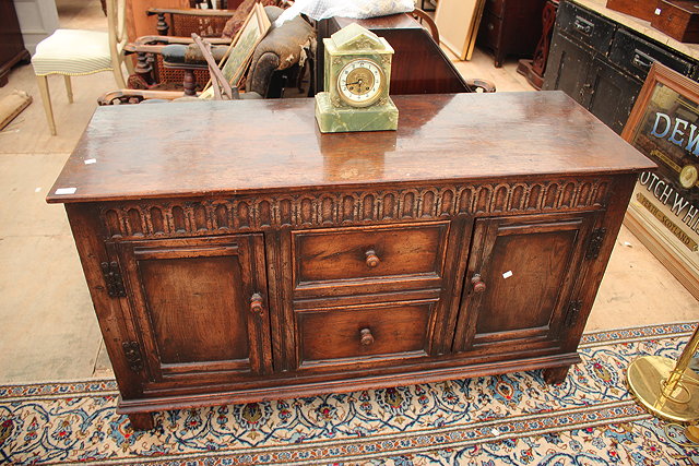 Appraisal: A TH CENTURY STYLE OAK RECTANGULAR SIDEBOARD fitted cupboards and