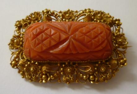 Appraisal: A VICTORIAN CORAL BROOCH the rounded oblong panel carved with