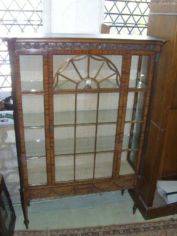 Appraisal: An Edwardian walnut display cabinet enclosed by a single glazed