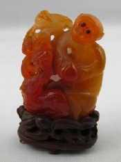 Appraisal: A Chinese variegated agate carved as a capuchin monkey with