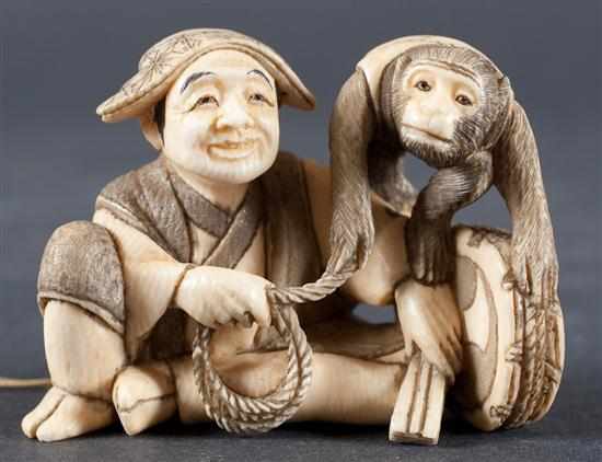 Appraisal: Japanese carved ivory netsuke street performer and monkey signed in