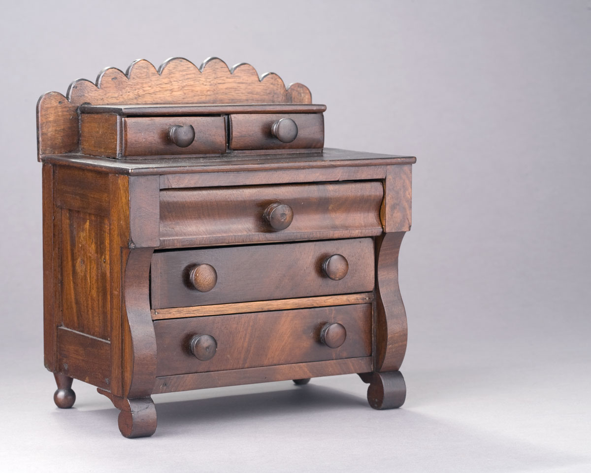 Appraisal: AMERICAN EMPIRE MAHOGANY MINIATURE CHEST OF DRAWERS The scalloped back