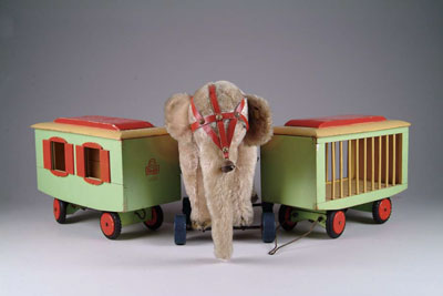 Appraisal: STEIFF ELEPHANT AND CIRCUS WAGONS Beautiful straw-stuffed elephant on wheels