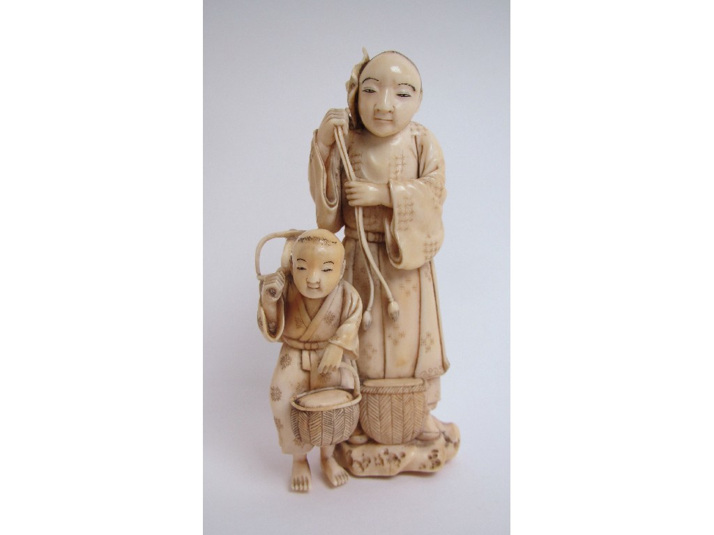 Appraisal: A Japanese ivory okimono carved with a father and son