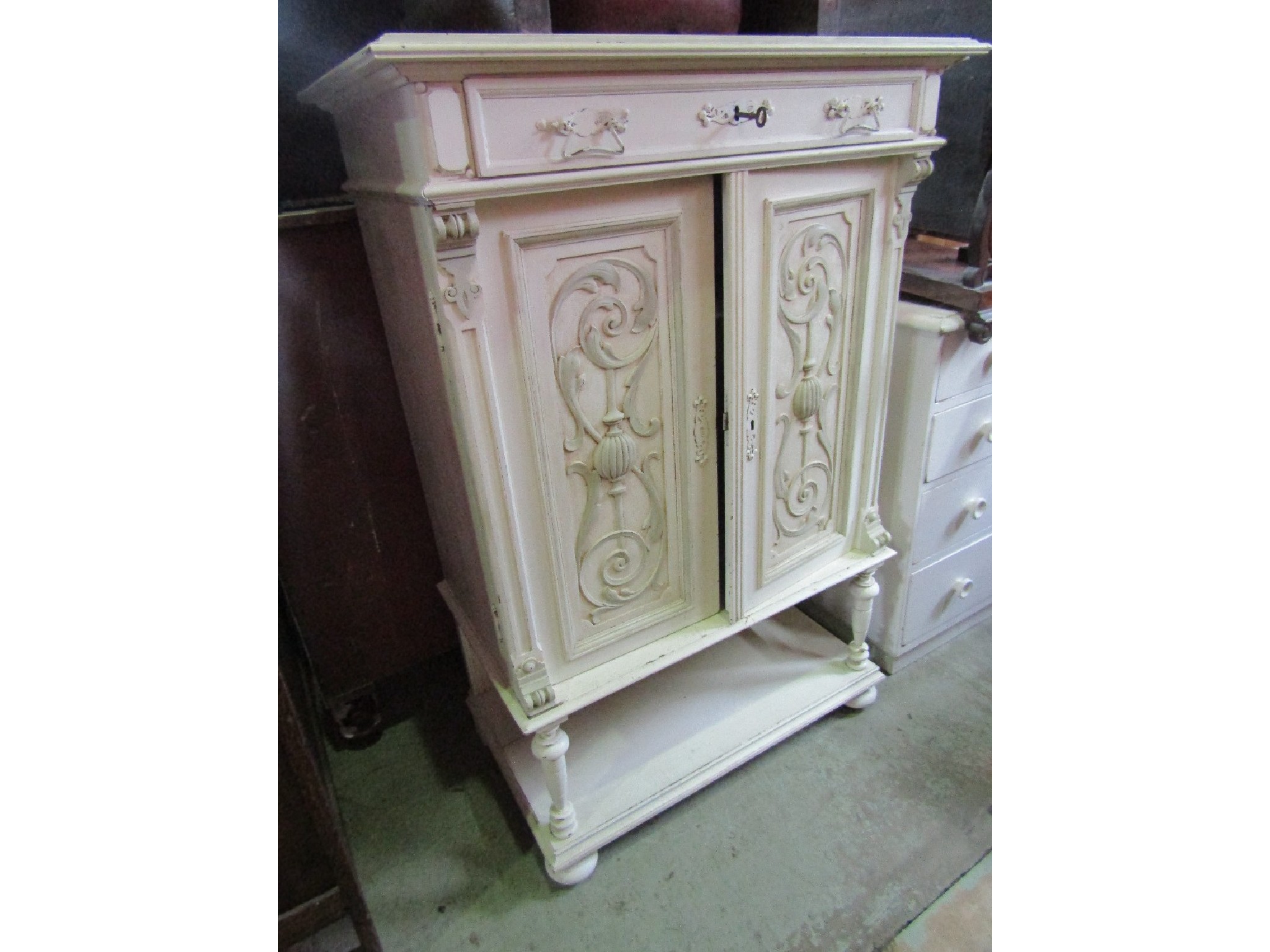 Appraisal: An Edwardian oak side cabinet with shallow frieze drawer over