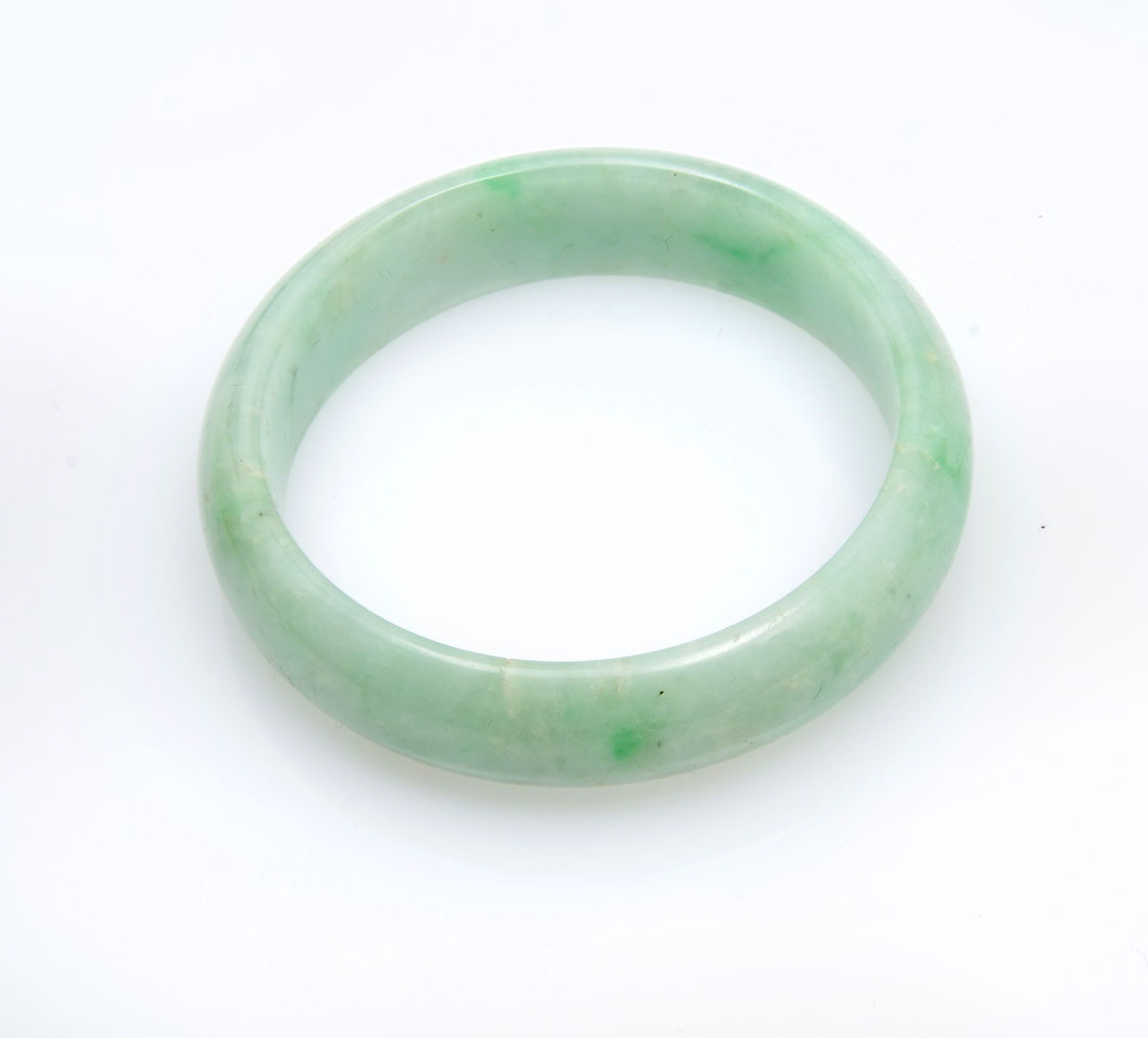 Appraisal: JADE BANGLE BRACELET Slightly brighter green tones in this ''