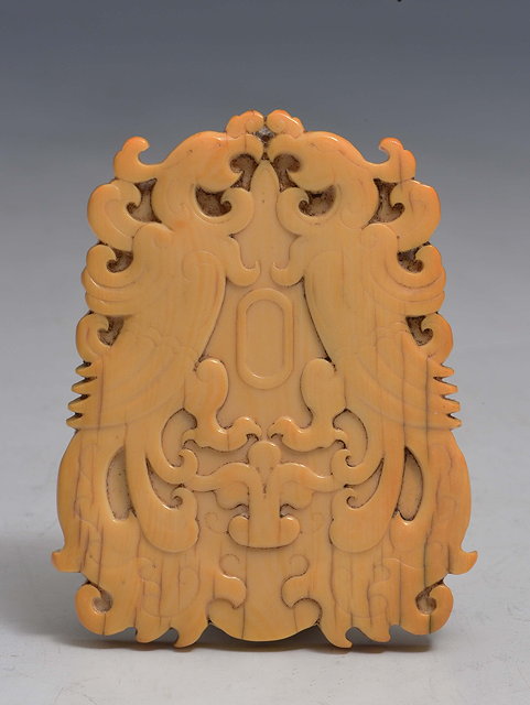 Appraisal: A CHINESE CARVED IVORY PENDANT each side decorated with a