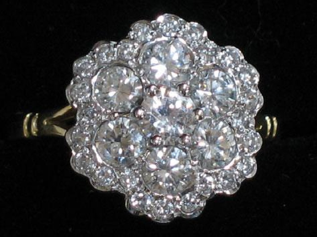 Appraisal: A DIAMOND CLUSTER RING the central round brilliant-cut diamond claw-set