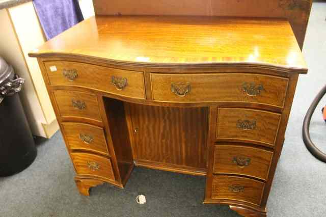 Appraisal: A REPRODUCTION MAHOGANY GEORGIAN STYLE SERPENTINE KNEE-HOLE DESK with crossbanded