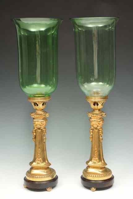 Appraisal: A PAIR OF ORMOLU COLUMN CANDLESTICKS with green glass hurricane