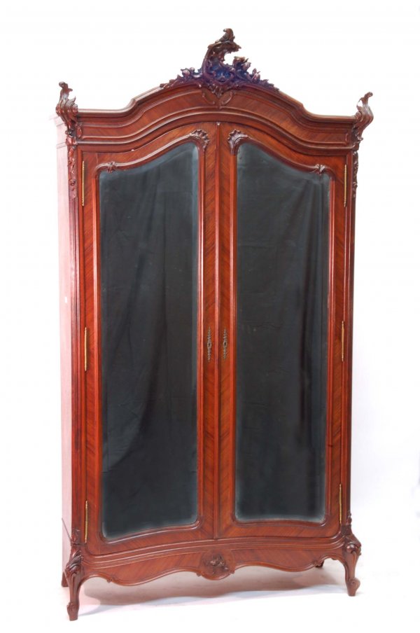 Appraisal: Armoire Two beveled glass mirrored doors Ornately carved overall Fruitwood