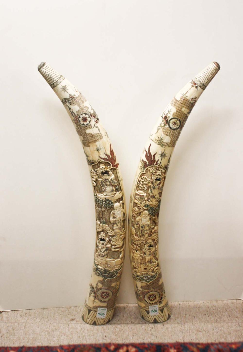 Appraisal: PAIR OF CARVED AND SCRIMSHAW DECORATED BONE TUSKS Chinese th