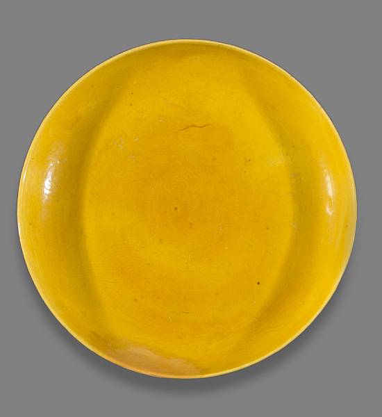 Appraisal: A yellow glazed porcelain charger with incised dragon decoration Ming