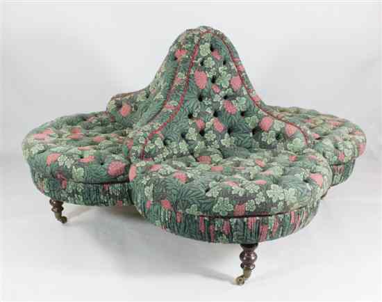 Appraisal: A Victorian mahogany conversation seat with floral upholstery on turned