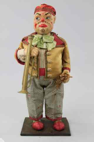 Appraisal: CLOWN MUSICIAN CLOCKWORK DISPLAY Hand painted composition head with glass