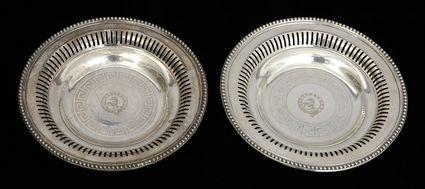 Appraisal: PAIR OF ENGLISH ARMORIAL SILVER-PLATED WINE BOTTLE COASTERS Each shallow