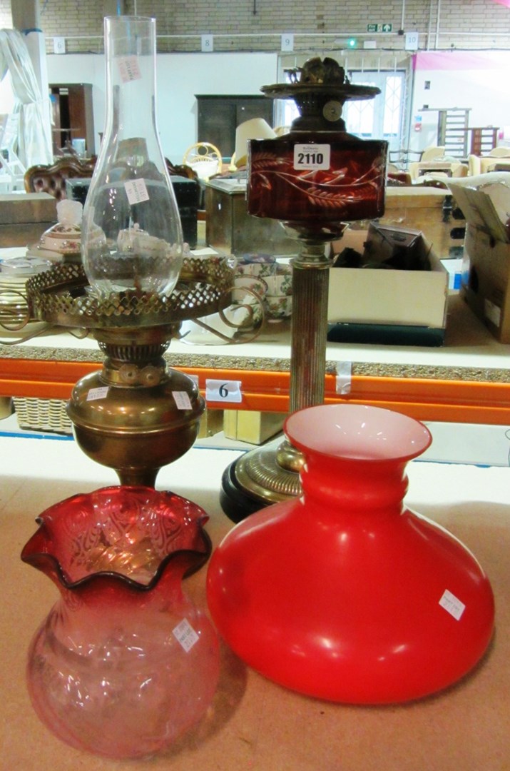 Appraisal: A brass oil lamp with reeded column and ruby reservoir