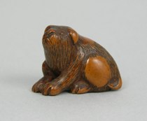 Appraisal: Seated Puppy Netsuke Japanese early th Century Charming wooden toggle