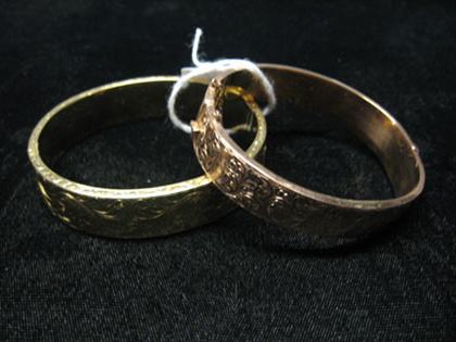 Appraisal: Two gold bangles etched with intricate swirling leaf designs