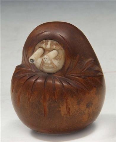 Appraisal: A CARVED WOODEN OKIMONO in the form of a swaddled