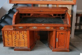 Appraisal: An early twentieth century walnut roll top desk with rotating