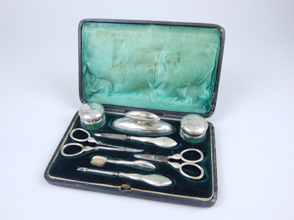 Appraisal: An Edwardian silver mounted manicure set comprising two cut glass