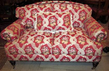 Appraisal: Victorian style sofa and armchairBoth with a shaped upholstered back