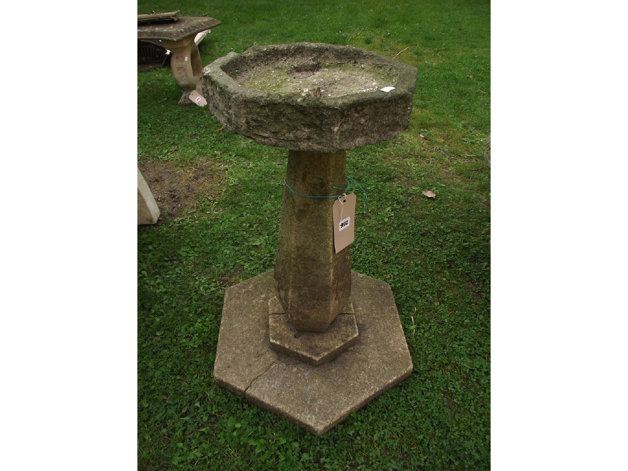 Appraisal: A weathered three sectional bird bath of octagonal form raised