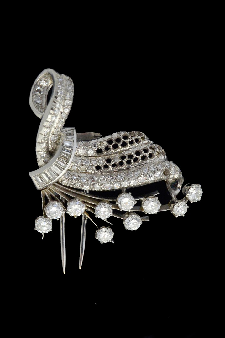 Appraisal: A diamond brooch in a scrolling and fanned design claw