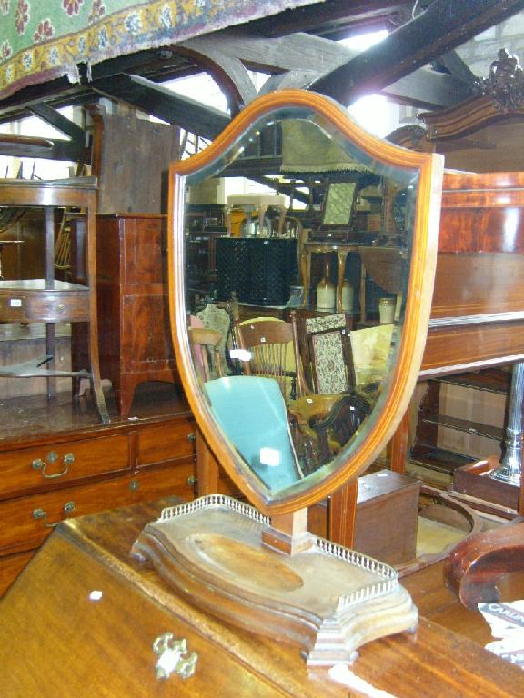 Appraisal: An Edwardian Georgian style shield shaped toilet mirror on platform