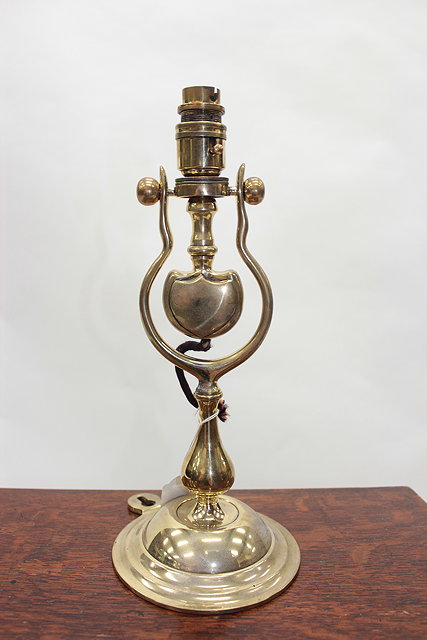 Appraisal: A SHIPS BRASS ELECTRIC LIGHT with hinged mount and circular