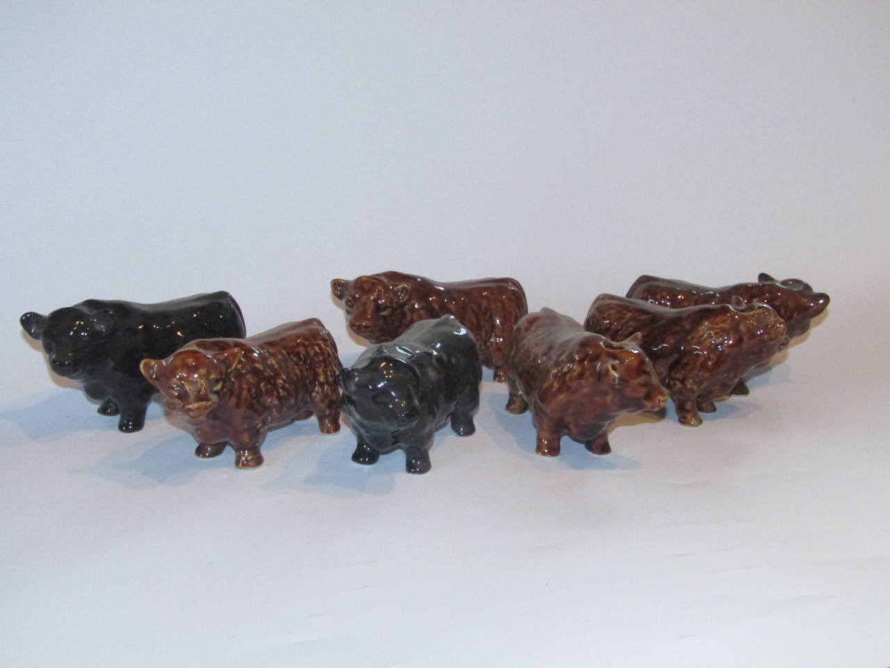 Appraisal: Seven various treacle glazed pottery figures of Highland and Aberdeen