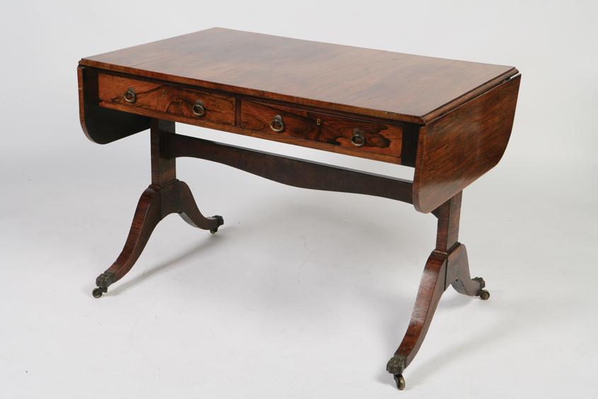 Appraisal: A REGENCY ROSEWOOD SOFA TABLE the rectangular top with twin