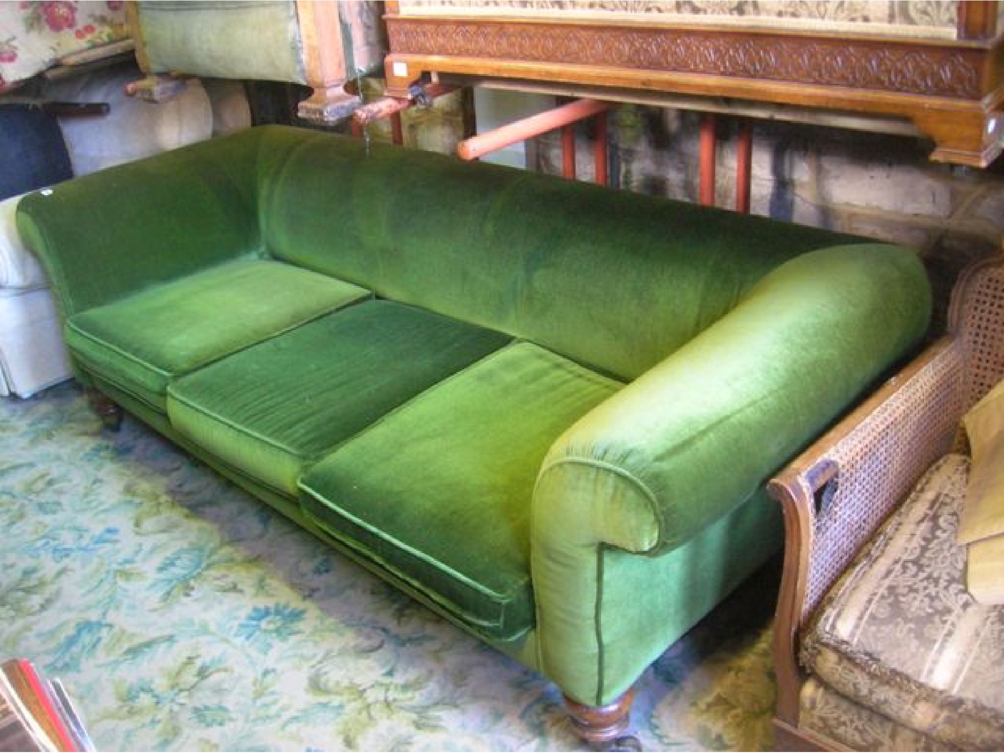 Appraisal: A Victorian three seat sofa with swept and rolled arms