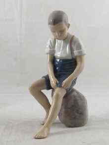 Appraisal: A Royal Copenhagen ceramic model of a boy on a