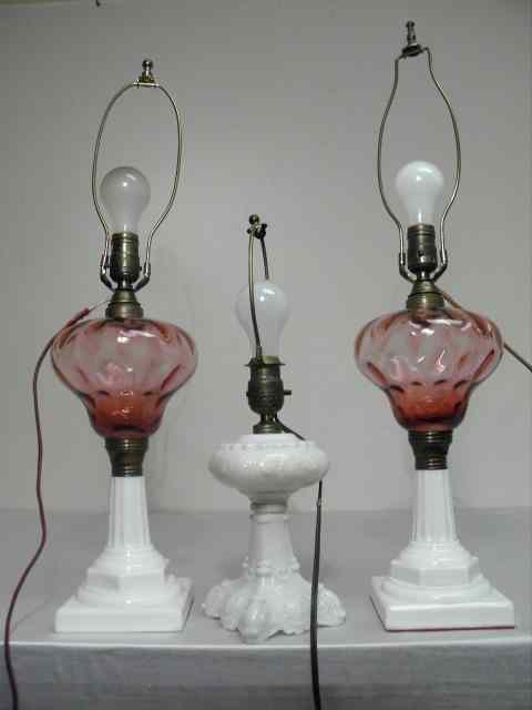 Appraisal: Three cranberry and milk glass table lamps Includes two matching