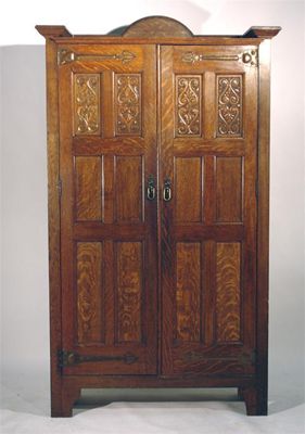 Appraisal: A Shapland Petter Arts and Crafts oak wardrobe with carved