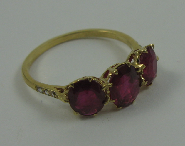 Appraisal: RUBY AND EIGHTEEN KARAT GOLD RING set with three mine-cut