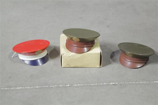 Appraisal: THREE HENRIETTE MILITARY HAT-SHAPED POWDER COMPACTS Including one with original