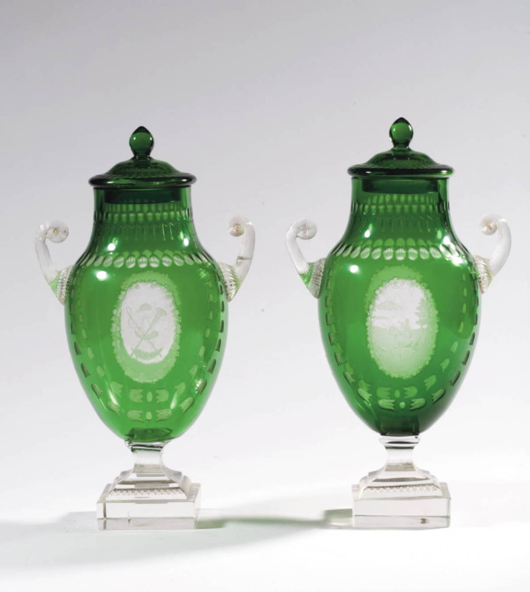 Appraisal: PAIR OF GREEN OVERLAY GLASS HUNTSMEN PISTOL-HANDLED COVERED MANTEL VASES