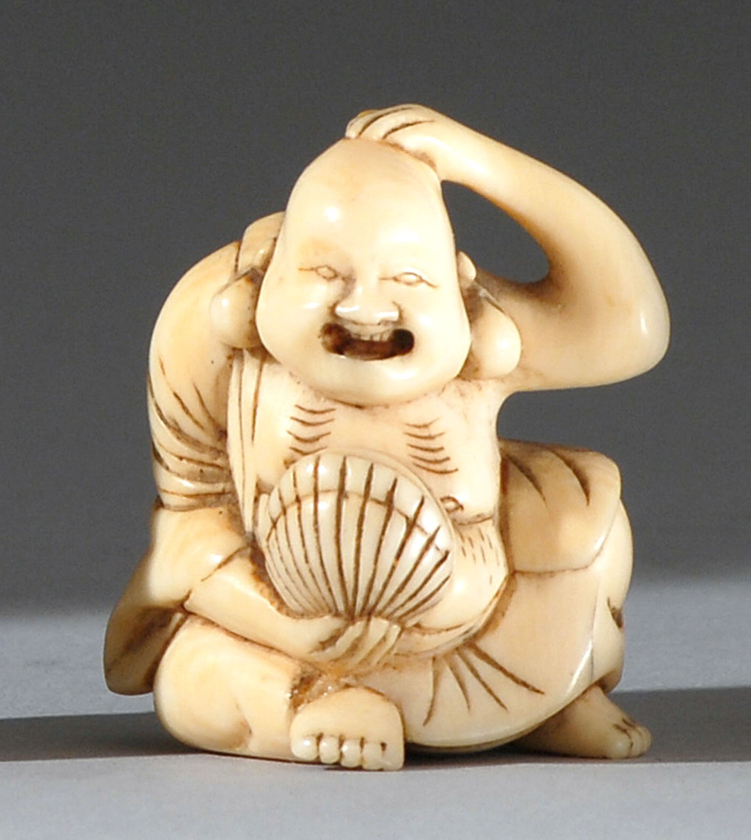 Appraisal: IVORY NETSUKE Early th CenturyIn the form of Hotei rubbing