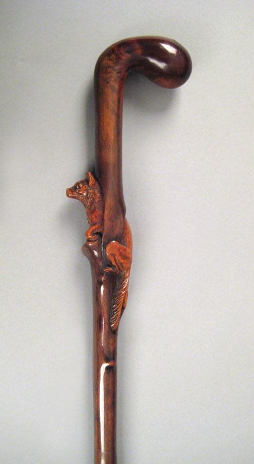 Appraisal: Burlwood cane with relief figure of a wolf crawling through