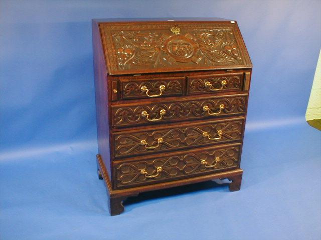 Appraisal: A Georgian carved oak bureau with fruit foliage and mask