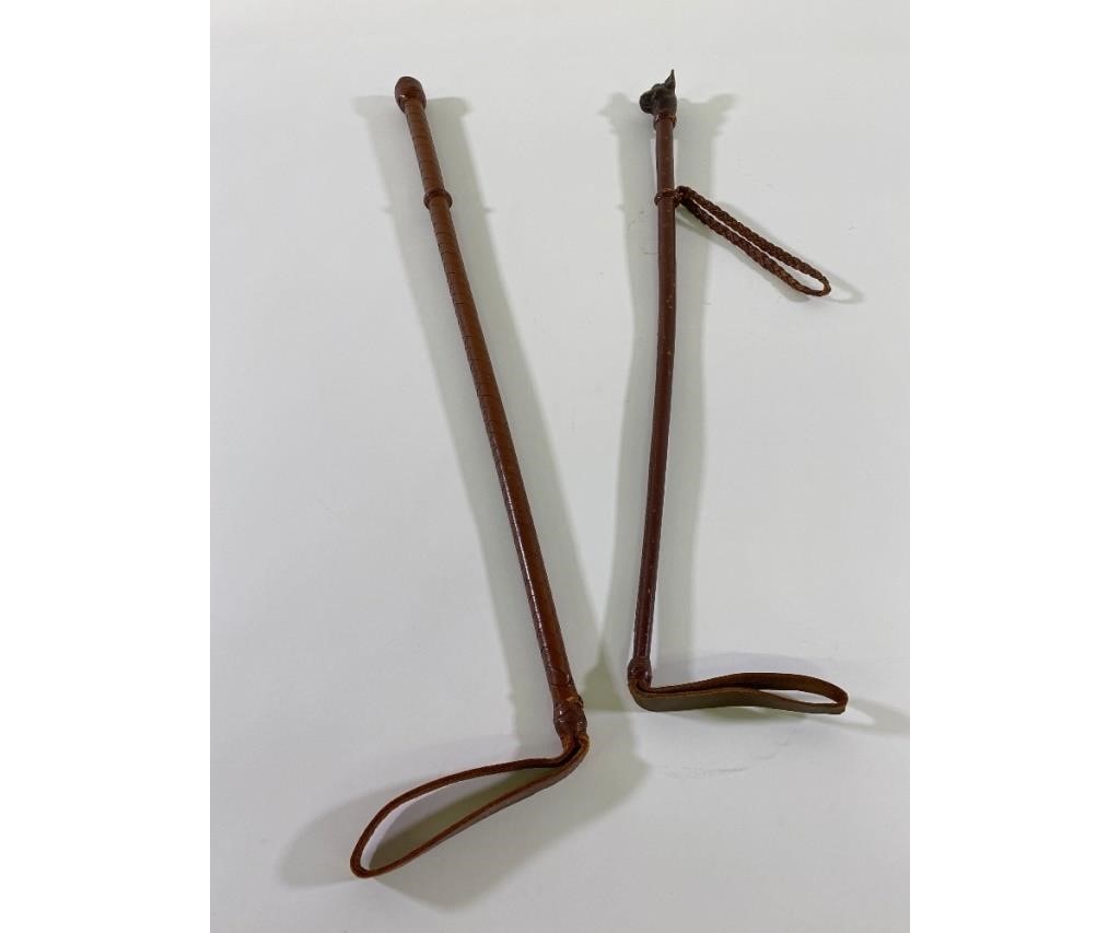 Appraisal: Two leather covered riding crops one with a carved boxer